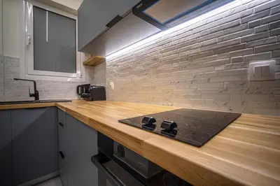 a kitchen with a wooden counter top and a brick wall at 