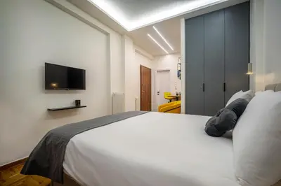 a bedroom with a white bed and a flat screen tv at 