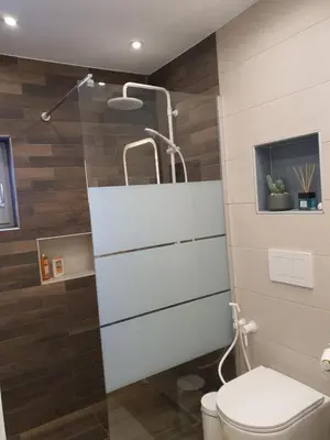 a bathroom with a toilet and a glass shower at Tony's suite with parking in Athens