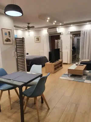 a living room with a table and chairs and a television at Tony's suite with parking in Athens