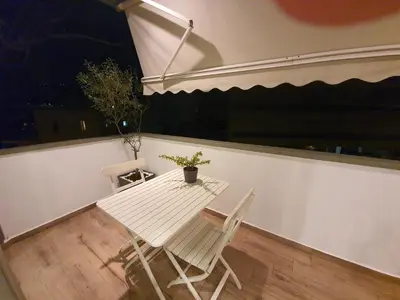 a white table and two chairs in front of a window at Tony's suite with parking in Athens
