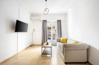 a living room with a couch and a tv at Lovely apartment in the heart of Athens in Athens