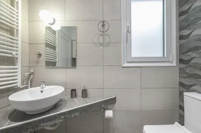 a white bathroom with a sink and a mirror at The 