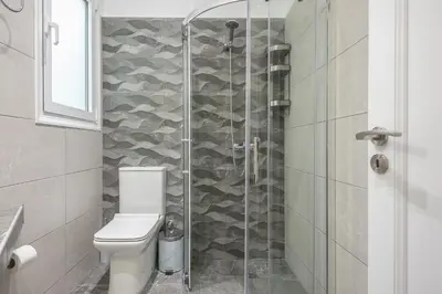a bathroom with a toilet and a glass shower at The 