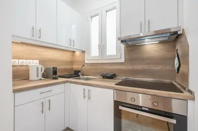 a kitchen with white cabinets and a sink at The 