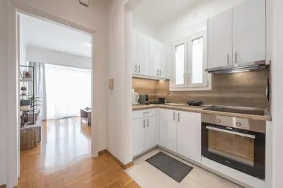 a kitchen with white cabinets and a large window at The 
