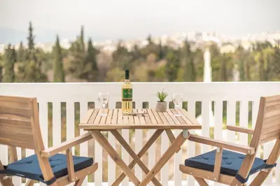 a wooden table with a bottle of wine and two chairs at The 