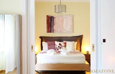 a bedroom with a bed with white sheets and pillows at MELMA PROPERTIES-AMAZONE-premium apartment in Piraeus center in Piraeus