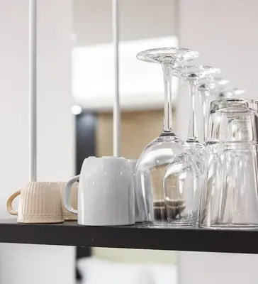 a shelf with glasses and cups and a mug at Xclusive Athens Suites in Athens