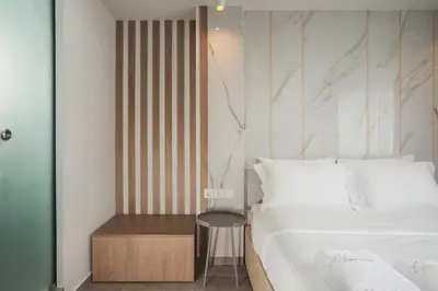 a bedroom with a bed and a stool next to a table at Xclusive Athens Suites in Athens