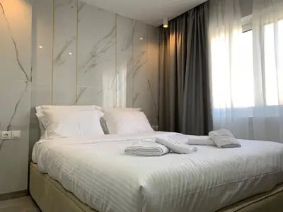a bedroom with a white bed with towels on it at Xclusive Athens Suites in Athens