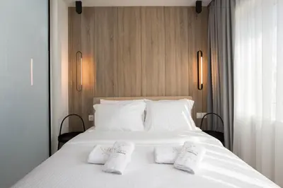 a bedroom with a white bed with white pillows at Xclusive Athens Suites in Athens