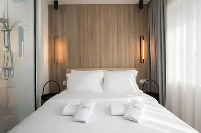 a bedroom with a white bed with two white socks on it at Xclusive Athens Suites in Athens