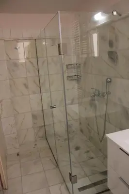 a shower with a glass door in a bathroom at Capital apartment next to Metro station with parking spot to explore Athens in Athens