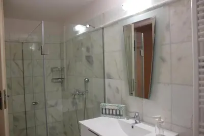 a bathroom with a shower and a sink and a mirror at Capital apartment next to Metro station with parking spot to explore Athens in Athens