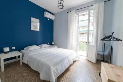 a blue bedroom with a bed and a window at Heart of Athens Thisio in Athens