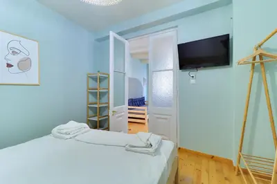 a room with a bed and a tv on a wall at athensvintage in Athens