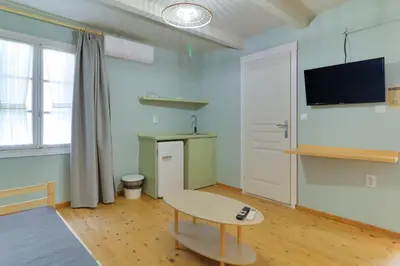 a living room with a table and a tv on the wall at athensvintage in Athens