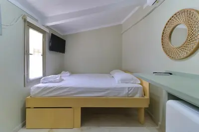 a small bedroom with a bed and a mirror at athensvintage in Athens