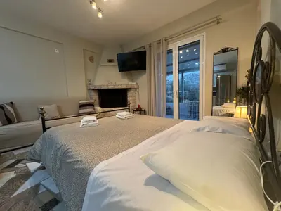 a bedroom with two beds and a fireplace at Detached House KATAFIGI in Palaiá Fókaia
