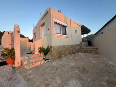 a house with a stone driveway in front of it at Detached House KATAFIGI in Palaiá Fókaia