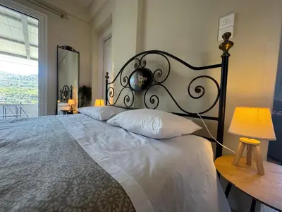 a bedroom with a large bed with a metal headboard at Detached House KATAFIGI in Palaiá Fókaia