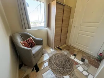 a living room with a chair and a window at Detached House KATAFIGI in Palaiá Fókaia