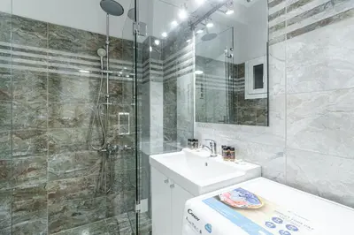 a white bathroom with a sink and a shower at Spacious 2BD apt next to metro in Athens