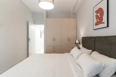 a bedroom with a large white bed with white pillows at Spacious 2BD apt next to metro in Athens
