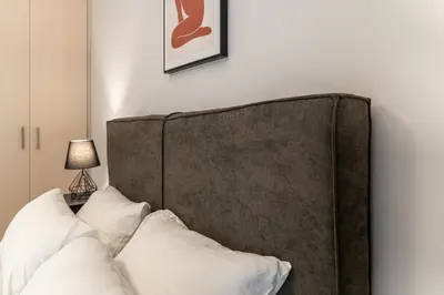 a bed with white pillows in a room at Spacious 2BD apt next to metro in Athens