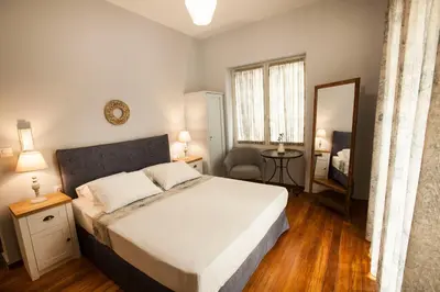 a bedroom with a large bed and a mirror at Lovely 1st Fl. Apt, with Balcony in Pagrati in Athens
