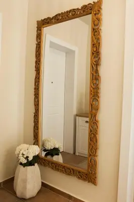 a mirror on a wall with two vases with flowers at Lovely 1st Fl. Apt, with Balcony in Pagrati in Athens