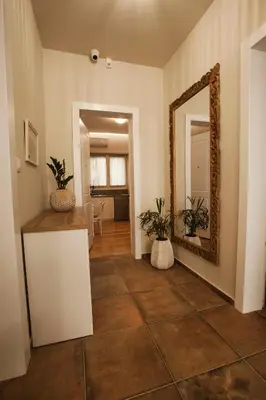 a living room with a mirror and a tile floor at Lovely 1st Fl. Apt, with Balcony in Pagrati in Athens