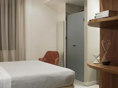 a bedroom with a bed and a chair next to a door at Athens City View Urban Suites in Athens