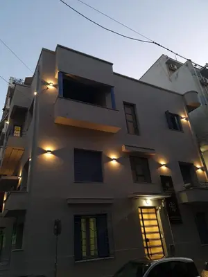 a building with lights on the side of it at Pagrati/Hilton area, Bentzi (3) Boutique Apt. for 4 in Athens