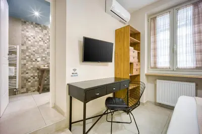 a bedroom with a desk and a tv on a wall at Pagrati/Hilton area, Bentzi (3) Boutique Apt. for 4 in Athens