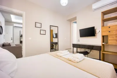 a bedroom with a white bed and a tv at Pagrati/Hilton area, Bentzi (3) Boutique Apt. for 4 in Athens