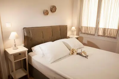 a bedroom with a bed with a headboard and two lamps at 2-spaces comfy Bentzi apartment 7 with balcony in Pagrati in Athens