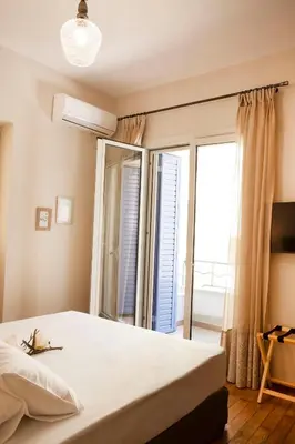 a bedroom with a bed and a large window at 2-spaces comfy Bentzi apartment 7 with balcony in Pagrati in Athens