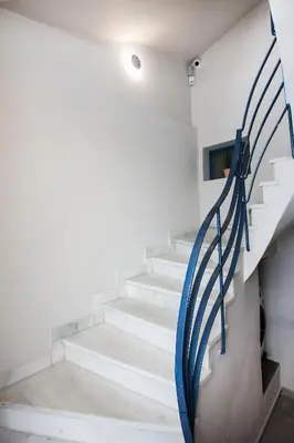 a staircase in a house with a blue railing at 2-spaces comfy Bentzi apartment 7 with balcony in Pagrati in Athens