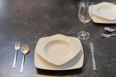 a table with white plates and silverware on it at Piraeus Port Exclusive in Piraeus