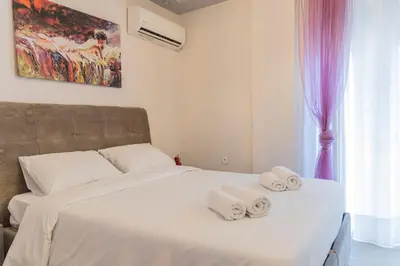 a bedroom with a white bed with towels on it at Piraeus Port Exclusive in Piraeus