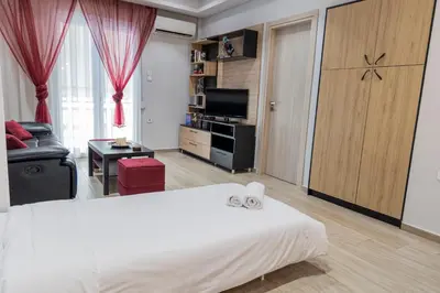 a bedroom with a large bed and a living room at Piraeus Port Exclusive in Piraeus