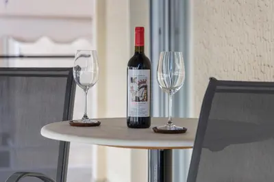 a bottle of wine sitting on a table with two wine glasses at Piraeus Port Exclusive in Piraeus