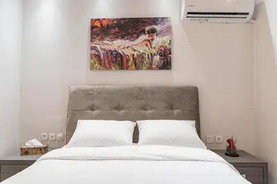 a bedroom with a bed with a painting on the wall at Piraeus Port Exclusive in Piraeus