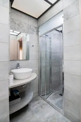 a bathroom with a glass shower and a sink at The 