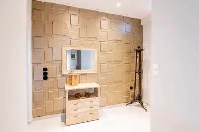 a bathroom with a wall with a mirror and a sink at The 