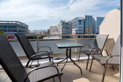 a patio with chairs and a table on a balcony at The 