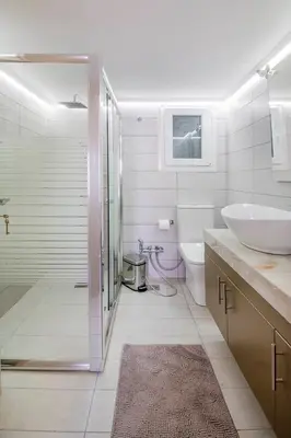 a bathroom with a shower and a sink and a toilet at The 