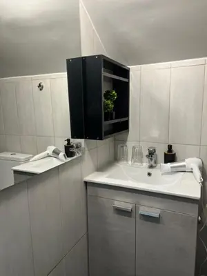 a white bathroom with a sink and a mirror at Thiseio Residence- Studio 55 in Athens